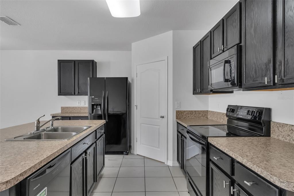 1828 Partin Terrace Road Kissimmee, FL 34744 - Photo 6 of 47 a kitchen with stainless steel appliances granite countertop a sink stove and refrigerator