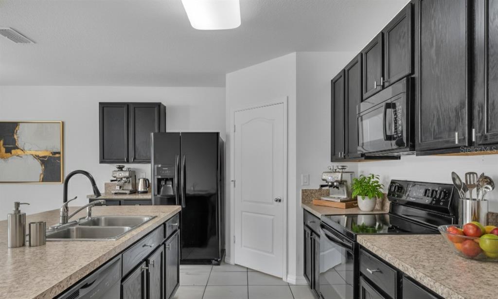 1828 Partin Terrace Road Kissimmee, FL 34744 - Photo 7 of 47 a kitchen with granite countertop a sink stove and refrigerator