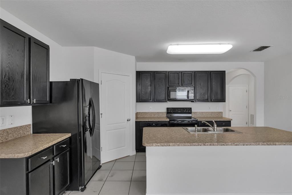 1828 Partin Terrace Road Kissimmee, FL 34744 - Photo 8 of 47 a kitchen with stainless steel appliances granite countertop a refrigerator and a stove