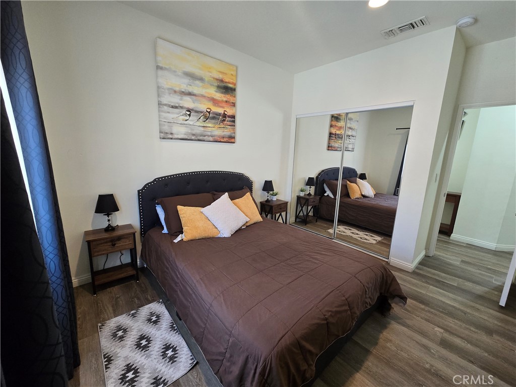 8026 Telegraph Road Downey, CA 90240 - Photo 13 of 26 a bedroom with a bed and wooden floor