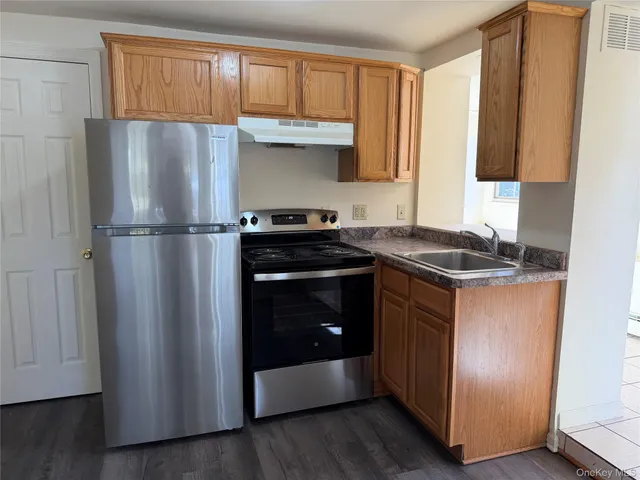 a kitchen with a refrigerator sink and cabinets