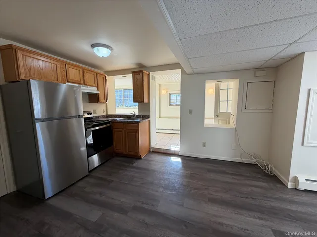a kitchen with stainless steel appliances wooden floor and large window