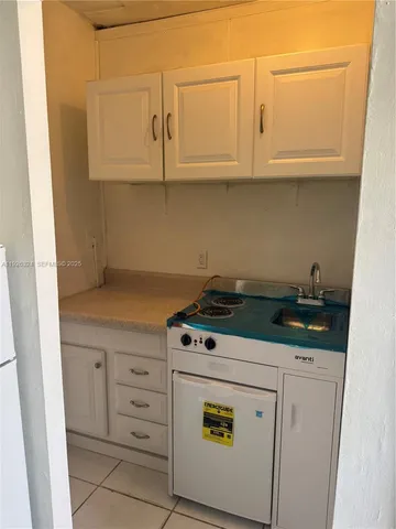a kitchen with granite countertop white cabinets and white appliances