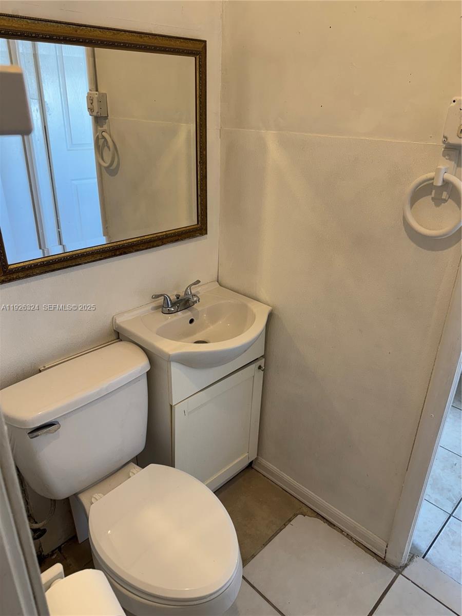 Boulevard Heights Pembroke Pines, FL 33024 - Photo 9 of 13 a bathroom with a toilet sink and mirror
