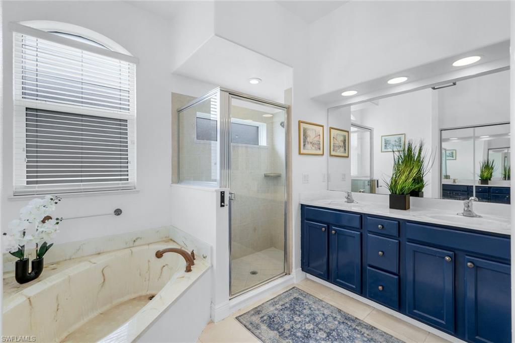 14846 Toscana Way Naples, FL 34120 - Photo 19 of 33 a bathroom with a tub sink and mirror