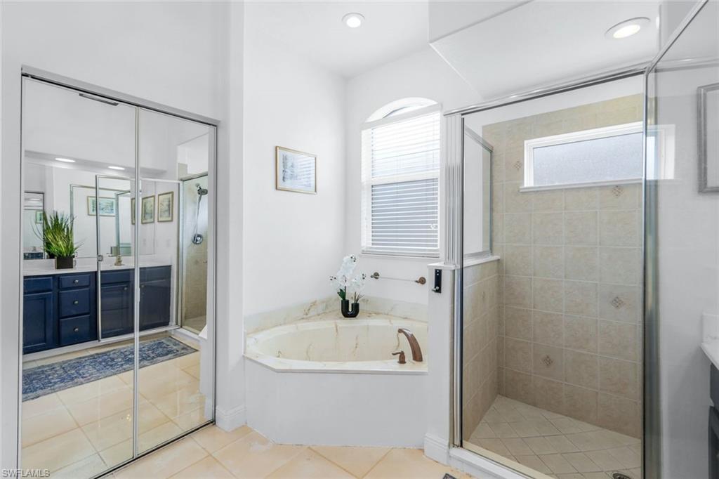 14846 Toscana Way Naples, FL 34120 - Photo 20 of 33 a bathroom with a bathtub and a shower