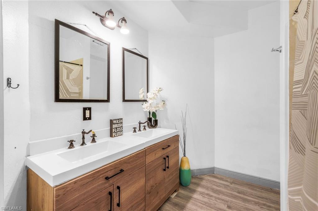 14846 Toscana Way Naples, FL 34120 - Photo 22 of 33 a bathroom with a sink vanity and a mirror