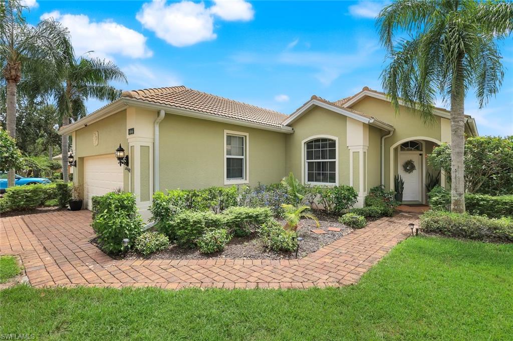 14846 Toscana Way Naples, FL 34120 - Photo 3 of 33 a front view of a house with a garden