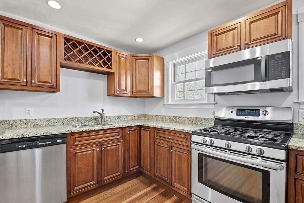 54 Thomas Street Dedham, MA 02026 - Photo 3 of 17 a kitchen with stainless steel appliances granite countertop a sink stove and cabinets
