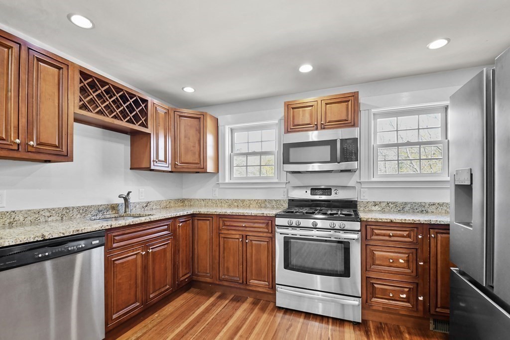 54 Thomas Street Dedham, MA 02026 - Photo 4 of 17 a kitchen with stainless steel appliances a stove sink microwave and cabinets