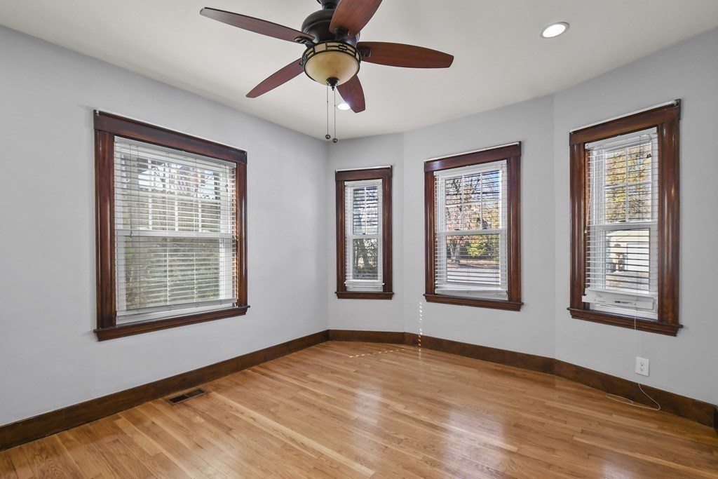 54 Thomas Street Dedham, MA 02026 - Photo 5 of 17 a view of an empty room with a window and wooden floor