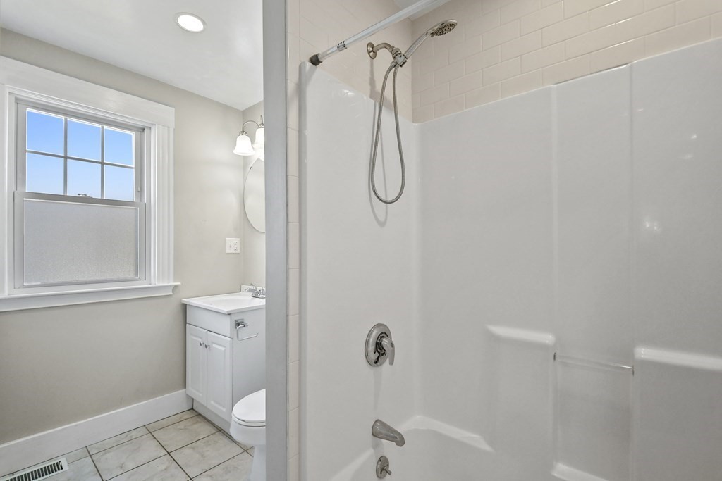 54 Thomas Street Dedham, MA 02026 - Photo 9 of 17 a bathroom with a granite countertop shower a toilet and a shower