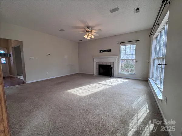 a view of an empty room with a fireplace and a window