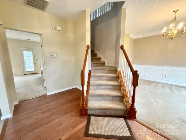 a view of a hallway with wooden floor and staircase