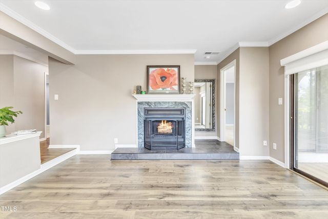 a view of a livingroom with wooden floor and a fireplace