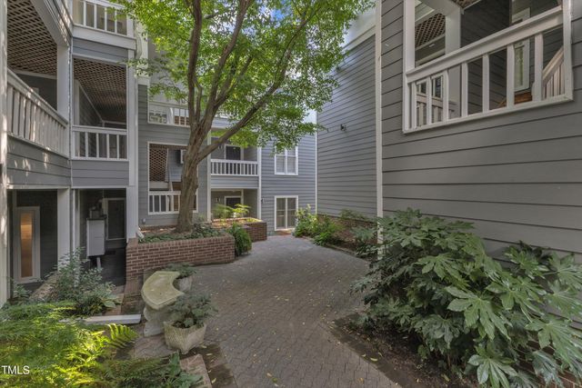 a view of a house with large windows and a table and chairs