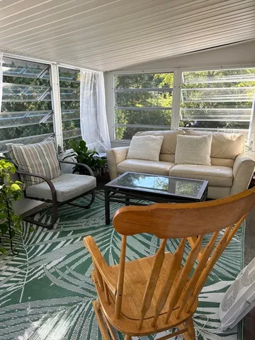 a living room with furniture fireplace and large windows