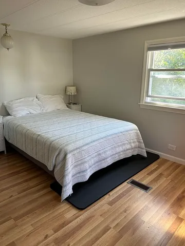 a bedroom with a bed and wooden floor