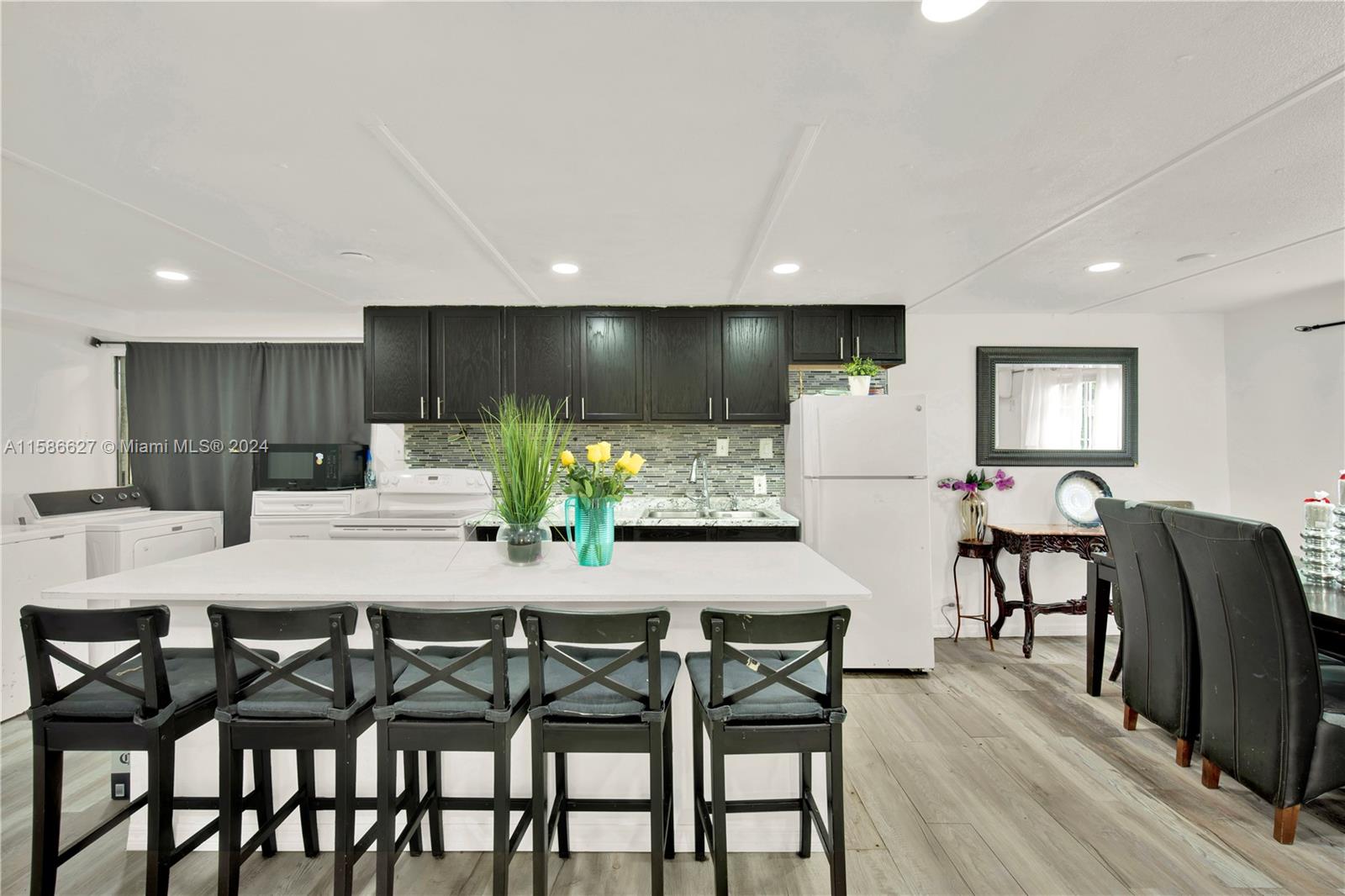 a kitchen with stainless steel appliances dining table chairs and cabinets