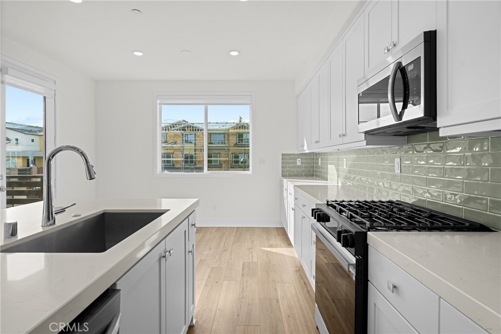 1713 Jade Road Rancho Mission Viejo, CA 92694 - Photo 20 of 53 a kitchen with sink a microwave and cabinets