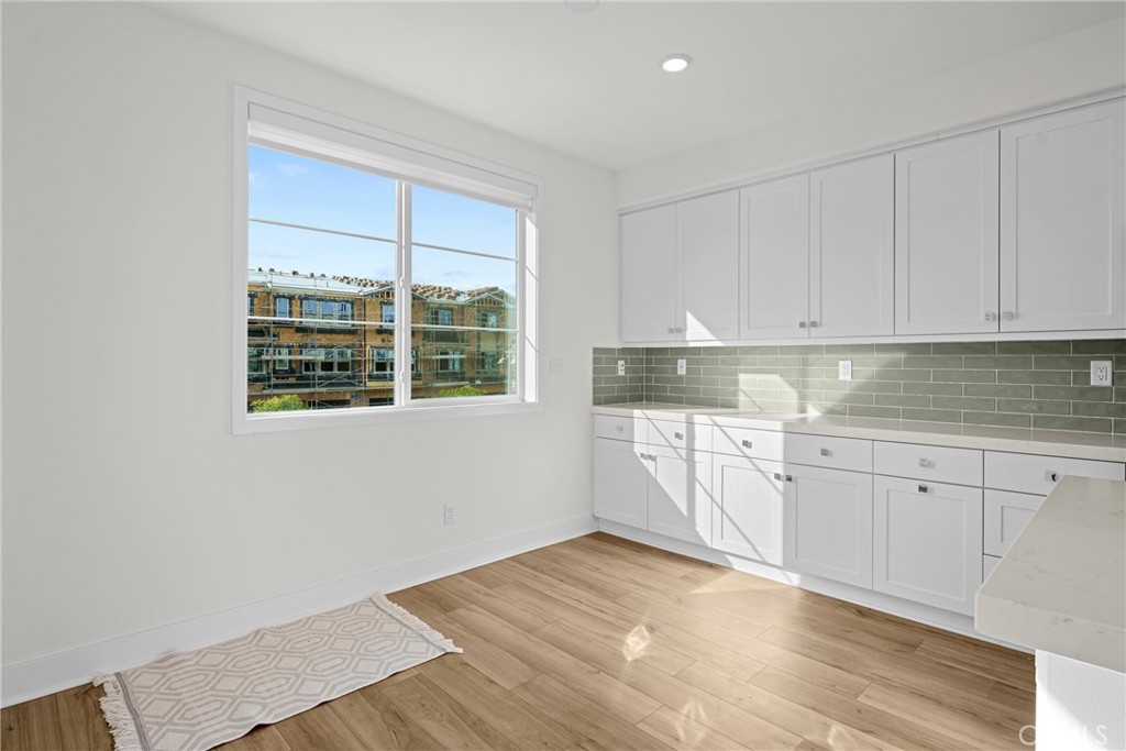 1713 Jade Road Rancho Mission Viejo, CA 92694 - Photo 24 of 53 a kitchen with granite countertop white cabinets and window