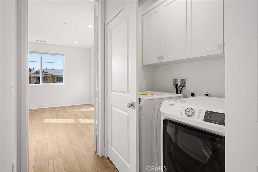 1713 Jade Road Rancho Mission Viejo, CA 92694 - Photo 36 of 53 a view of washer and dryer with kitchen in the background