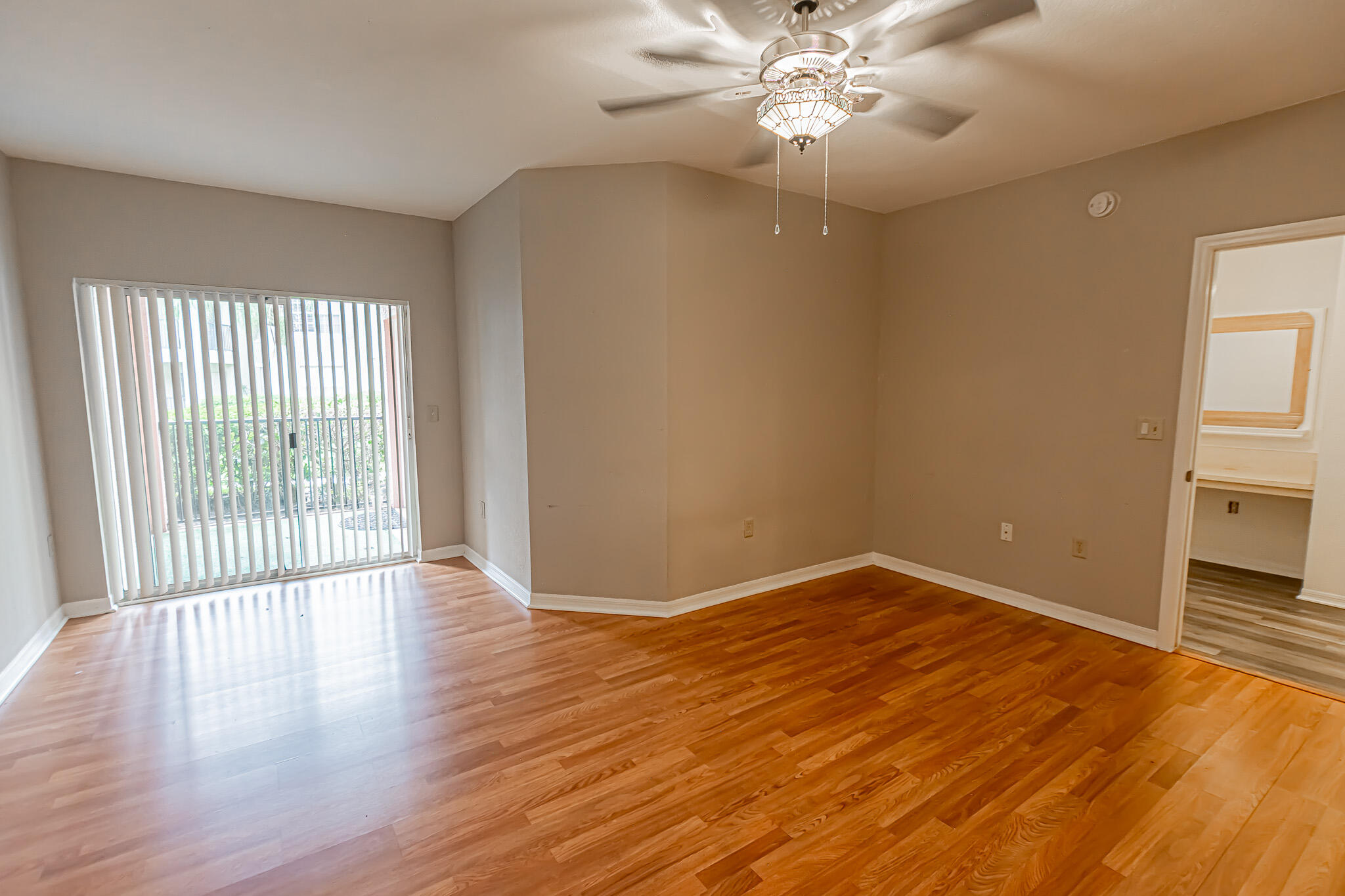 168 Southwest Peacock Boulevard, Unit 35103 Port St. Lucie, FL 34986 - Photo 11 of 43 an empty room with wooden floor fan and windows