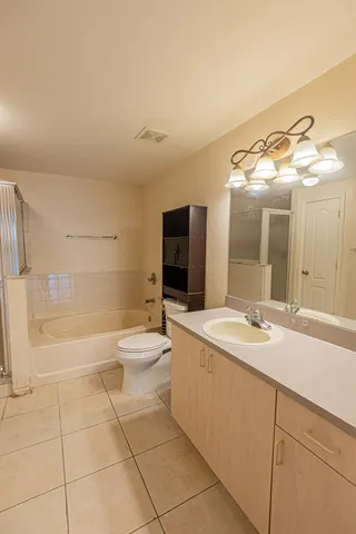 a bathroom with a sink a toilet and a large mirror