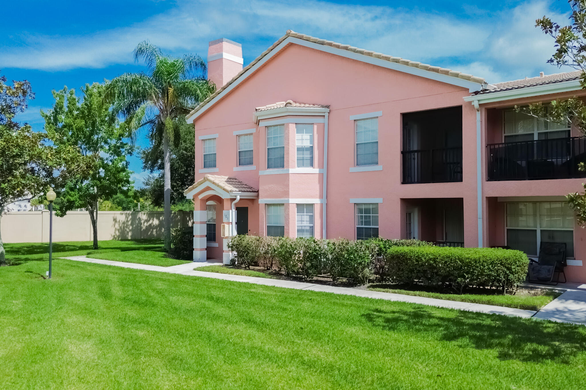 168 Southwest Peacock Boulevard, Unit 35103 Port St. Lucie, FL 34986 - Photo 2 of 43 a front view of a house with a yard