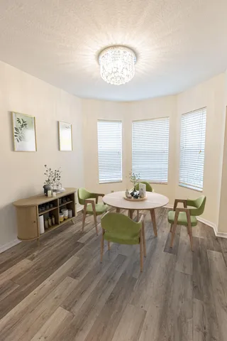 a living room with furniture a table and large windows