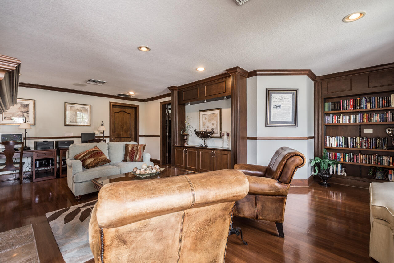 168 Southwest Peacock Boulevard, Unit 35103 Port St. Lucie, FL 34986 - Photo 31 of 43 a living room with furniture a rug and a bookshelf