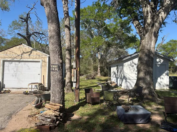 a view of a backyard with table and chairs and a large tree