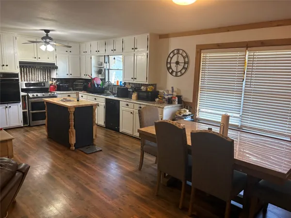 a kitchen with a table chairs stove and cabinets