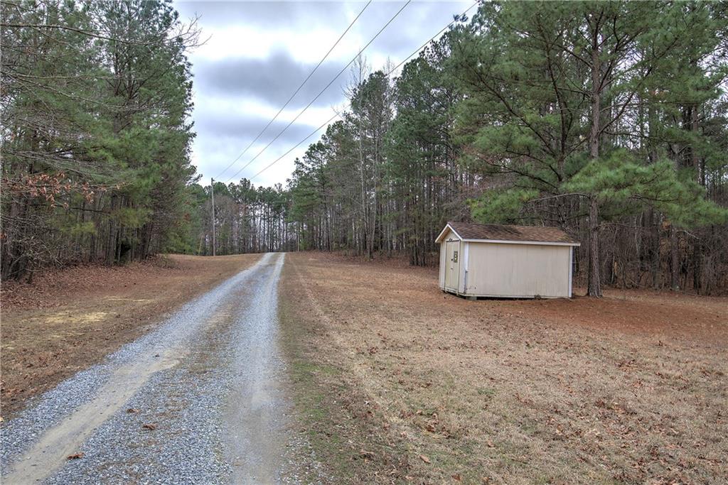 265 Evans Drive Buchanan, GA 30113 - Photo 78 of 123 a view of a dry yard with a barn and large trees