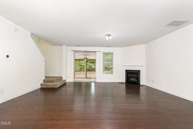 an empty room with floor to ceiling window and fireplace