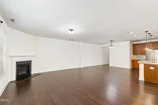 an empty room with wooden floor and fireplace