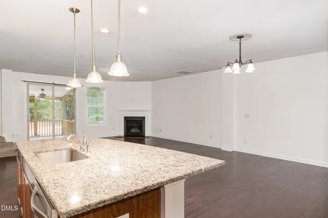 a kitchen with a sink chandelier and a fireplace