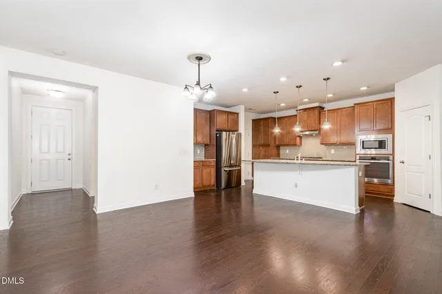 a view of kitchen with kitchen island white cabinets and stainless steel appliances