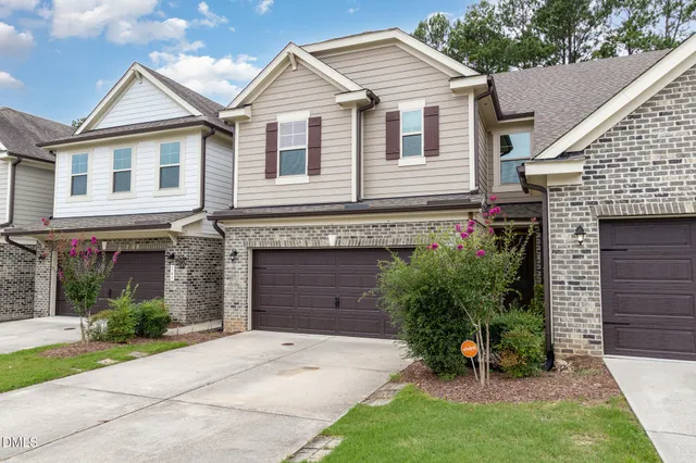 a view of a white house with a yard and plants