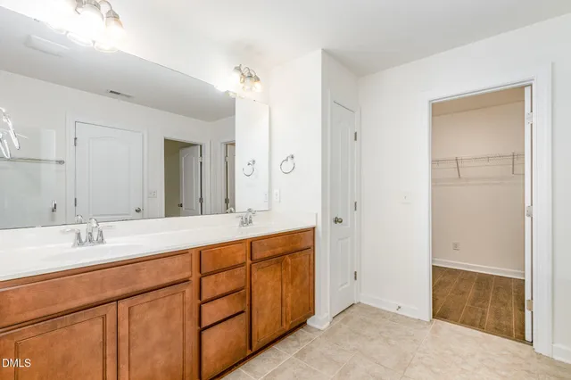 a spacious bathroom with a double vanity sink mirror and shower