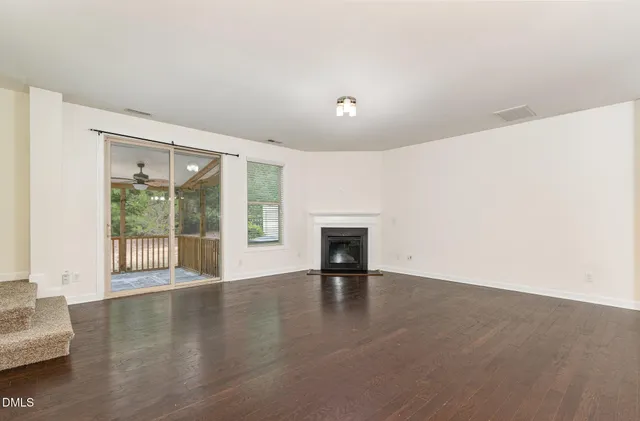an empty room with floor to ceiling window and an outdoor view