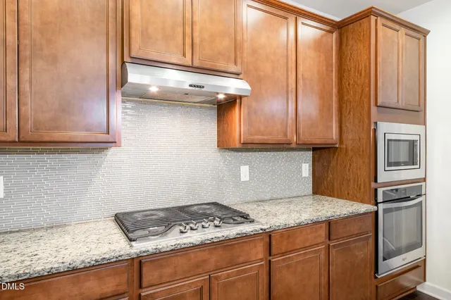 a kitchen with granite countertop cabinets stainless steel appliances and a counter space