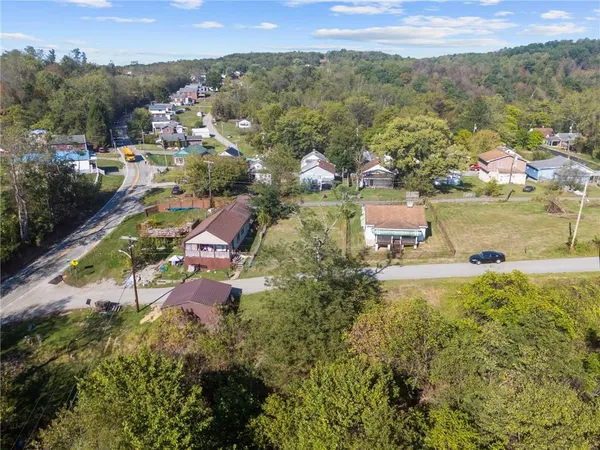 an aerial view of residential houses with outdoor space and lake view