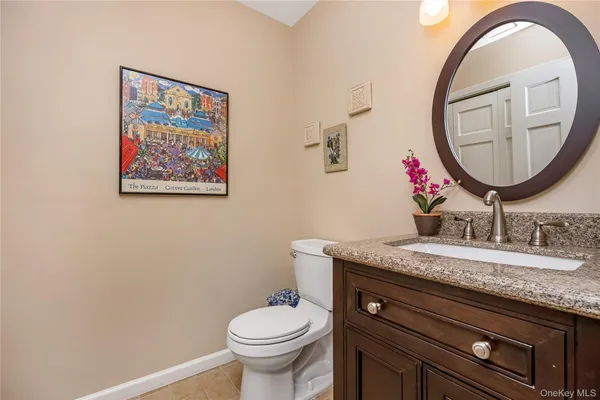 a bathroom with a granite countertop toilet a sink and a mirror