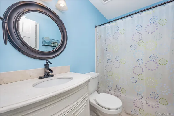 a bathroom with a sink a toilet and a mirror