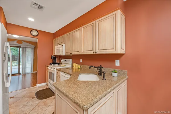 a kitchen with stainless steel appliances granite countertop a sink a stove and a refrigerator