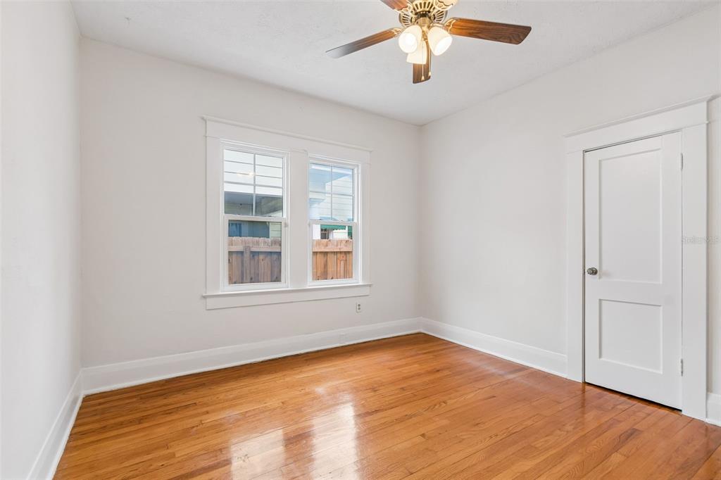 2434 West Prospect Road Tampa, FL 33629 - Photo 20 of 45 an empty room with wooden floor chandelier fan and windows