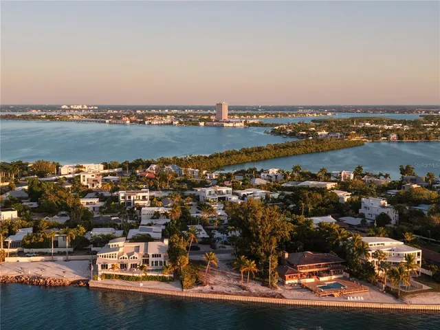 an aerial view of residential houses with outdoor space and ocean view