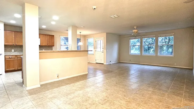 a view of empty room with wooden floor and windows