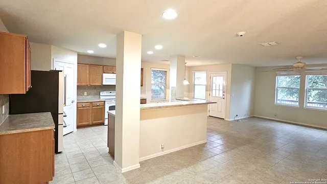 a large kitchen with a large counter top appliances and cabinets